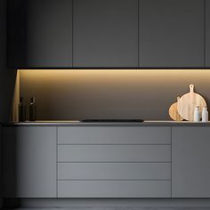 a modern kitchen with grey cabinets and white counter tops, along with an illuminated cutting board