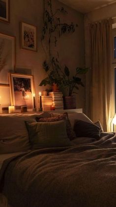 a bed sitting next to a window with candles on top of it and pictures above