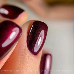 a woman's hand with a purple manicure and red nail polish on it