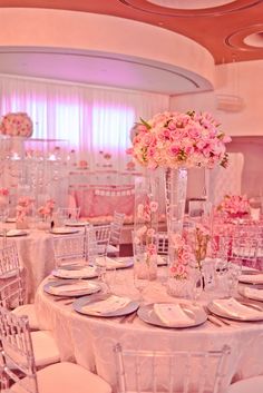 the tables are set with white linens and pink flowers