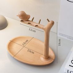 a wooden bird on a stand with measurements