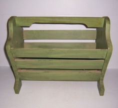 a green wooden toy bench sitting on top of a white floor