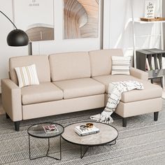 a living room with a couch, coffee table and pictures on the wall above it