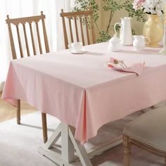 a table with two chairs and a pink table cloth