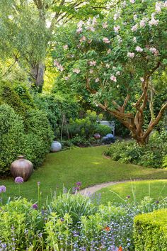 a lush green garden with lots of flowers and trees