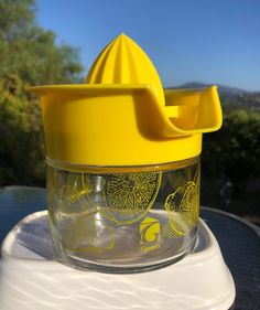 a yellow lid on a glass jar sitting on top of a table