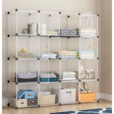 a white shelving unit filled with lots of clothes