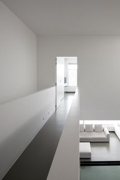 a room with white walls and flooring that is very minimalististic, but clean