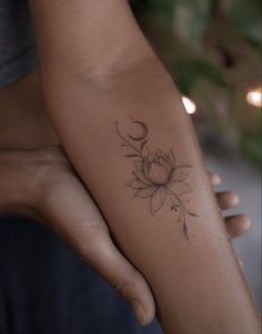 a woman's arm with a flower tattoo on the left side of her arm