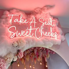 a neon sign that says take a seat, sweet cheeks