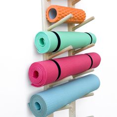 a rack with yoga mats on it and two oranges hanging from the wall next to each other