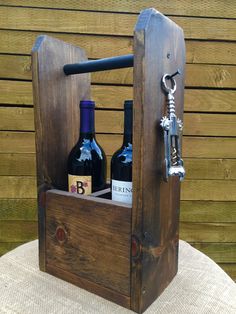 a wine bottle holder with two bottles in it and a skeleton key hanging from the handle