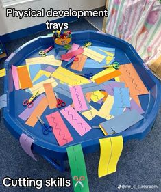 a blue table topped with lots of cut out pieces of paper on top of it