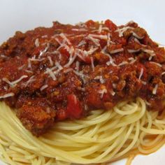 spaghetti with meat sauce and parmesan cheese on top