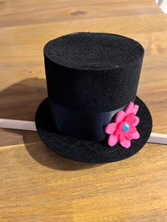 a black top hat with a pink flower on it