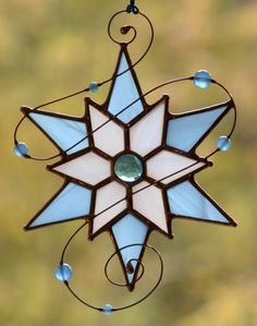 a stained glass star ornament hanging from a chain