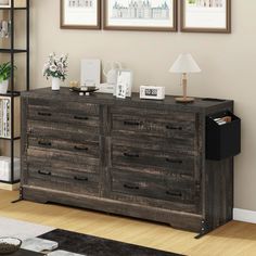 a large wooden dresser sitting in a living room next to two pictures on the wall