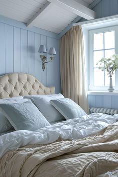 a large bed sitting in a bedroom next to a window with two lamps on top of it