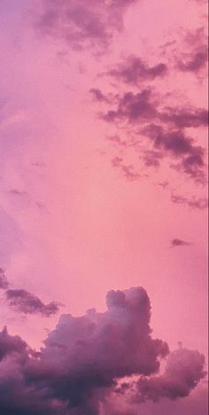 an airplane is flying in the sky at sunset or dawn with pink and purple clouds