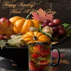 a coffee mug sitting on top of a table filled with autumn leaves and pumpkins