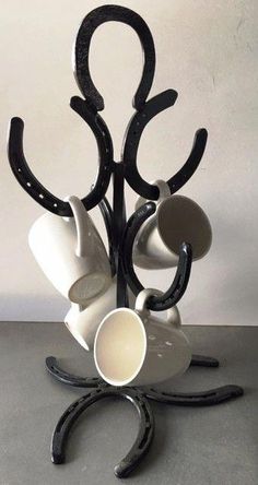 a black and white sculpture with coffee cups on it