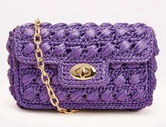 a purple crocheted purse with a gold chain hanging from the front and side