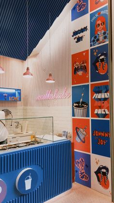 the interior of a fast food restaurant with blue and orange stripes on the wall behind the counter