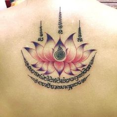 the back of a woman's shoulder with an intricate flower tattoo design on it