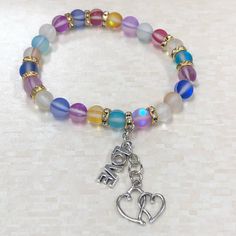 Beautiful Handmade Multicolored Aurora Glass Stone Bracelet W Love Charms Beautiful 8 Mm Aurora Glass Beads With Gold Crystal Spacer Beads Can Be Made To Order In Any Size Can Be Made With Or Without Hanging Charms Bracelets Are All Hand Strung On 1 Mm Elastic String. String Is Very Strong But If Stretched Too Far Meaning Out Of The Normal Use Can Break. As With All Handmade Items There Might Be Slight Imperfections Thank You For Checking Out My Closet Please Message Me With Any Questions Before Aquamarine Bracelet Beads, Hanging Charms, Rose Quartz Bracelet Beads, Garnet And Gold, Charms Bracelets, Rose Quartz Beads, Braided Leather Bracelet, Black Bracelets, Love Charms