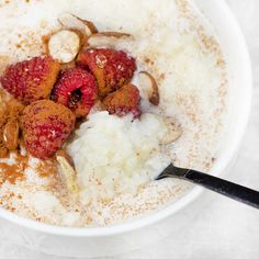 a bowl of oatmeal with raspberries and almonds in it