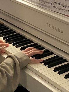 a young boy is playing the piano with his hands