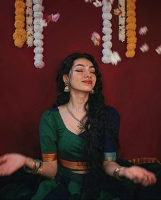 a woman sitting in the middle of a room with her eyes closed and hands out