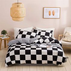 a black and white checkered comforter on a bed in a room with two chairs