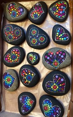 painted rocks in a box with hearts on them