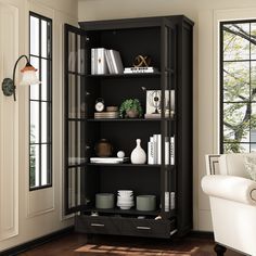 a black bookcase with many books and vases on it in a living room