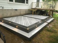 a deck with lights on it in front of a house