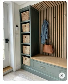 a coat rack with baskets on it and a purse hanging from the top, next to an entryway