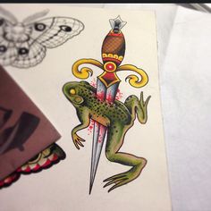 a drawing of a frog with a knife in it's mouth and an insect on its back