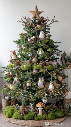 a christmas tree with ornaments and moss on the bottom is decorated in gold, green and white