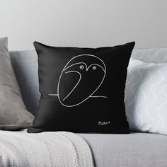 a black and white pillow sitting on top of a couch next to a gray throw pillow