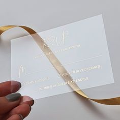 a person holding a piece of paper with a gold ribbon on it