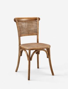 a wooden chair with wicker seat and back rests on a white surface, facing the camera