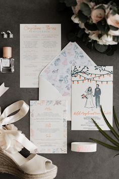 the wedding stationery is laid out on top of the table with shoes and flowers