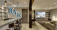 a bar with stools in front of it and a television on the wall behind it