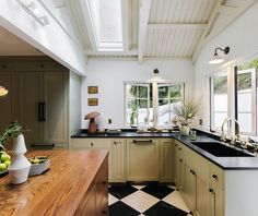 a kitchen with black and white checkered flooring next to a wooden counter top