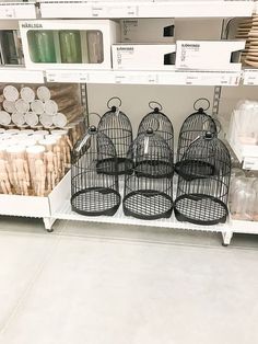 several bird cages sitting on top of a shelf in a store