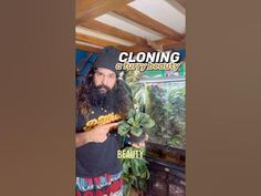 a man with long hair and beard wearing a black hat is standing in front of an aquarium