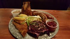 a plate with meat, vegetables and sauces on it