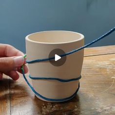 someone is making a cup out of yarn