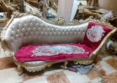 an ornate couch with pink velvet and gold trimmings in a room filled with mirrors